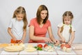 Mom teaches two daughters to cook