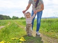 Mom teaches walks young son. Royalty Free Stock Photo