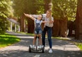 Mom Teaching Daughter To Ride Segway Having Fun Outdoors