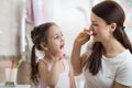 Mom teaching kid daughter teeth brushing in bathroom