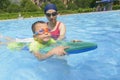 Mom teaching son learn to swim in summer