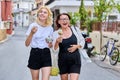 Mom and teen daughter having fun eating ice cream walking along street of old city Royalty Free Stock Photo