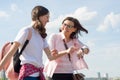 Mom and teen daughter walking along city street. Mother showing her daughter clock on the hand, women quickly go Royalty Free Stock Photo