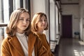 Mom and teenage daughter in yellow clothes relax by the window .Parents and teens. Family look Royalty Free Stock Photo