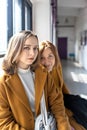 Mom and teenage daughter in yellow clothes relax by the window .Parents and teens. Family look Royalty Free Stock Photo