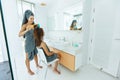 Mom brushing hair to her daughter in hotel bathroom Royalty Free Stock Photo