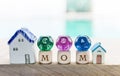 Mom text on wooden cube with divination dice and miniature home over blurred background Royalty Free Stock Photo