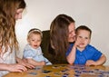Mom and Three Kids Doing A Puzzle Royalty Free Stock Photo