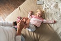 Mom tickles her little daughter`s feet. The girl laughs merrily. Royalty Free Stock Photo