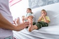 Mom tickles her son`s bare heels. The boy is sitting on the sofa and laughing merrily