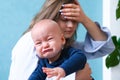 Mom tired trying to calm her crying baby. Newborn tantrum child on mother hands. Family life, motherhood