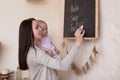 Mom and Toddler Daughter playing menu planning write to blackboard and chalk, Royalty Free Stock Photo