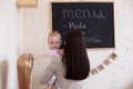 Mom and Toddler Daughter playing menu planning write to blackboard and chalk, Royalty Free Stock Photo