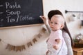 Mom and Toddler Daughter playing menu planning write to blackboard and chalk, Royalty Free Stock Photo