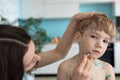 Mom treats her son, treats blemishes and blisters on her face. Royalty Free Stock Photo