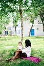 Mom turned her head to the little girl sitting on a blanket on the lawn Royalty Free Stock Photo