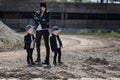 Mom with twins in leather jackets and caps.Mother and sons