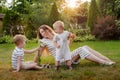 Mom, two children rest on nature. Sibling rivalry. Brothers, Motherhood.