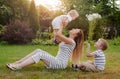 Mom, two children rest on nature. Sibling rivalry. Brothers, Motherhood.