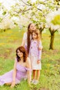 mom and two daughters. A family in a blossoming spring garden. Royalty Free Stock Photo