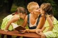 Mom and two lovely daughters give each other kisses in the summer forest Royalty Free Stock Photo