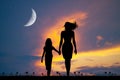 Mom walks with her daughter at sunset