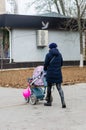 Young woman with a pram on the street.