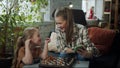 Mom watches a chess lesson on her phone and tells her daughter how the pieces move Royalty Free Stock Photo