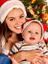 Mom wearing Santa hat holding baby son under Royalty Free Stock Photo