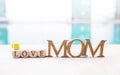 Mom wooden font with love wooden cube and coffee cup on swimming pool edge