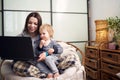 Mom working with laptop computer at home and playing with her baby. Quarantine concept Royalty Free Stock Photo