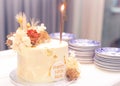 Mom's 50th birthday cake with lighted candle and plates background blur selective focus noise Royalty Free Stock Photo
