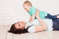 Mom and young boy son lying on the wooden floor play Royalty Free Stock Photo