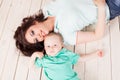 Mom and young boy son lying on the wooden floor Royalty Free Stock Photo