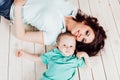 Mom and young boy son lying on the wooden floor Royalty Free Stock Photo