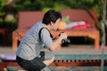 The moment of Asian Thai Professional photographer is kneeling and wating for take a great photo