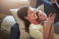 The moment she fell in love with books. a mother and her daughter reading a book together on the sofa at home. Royalty Free Stock Photo