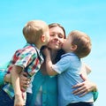 Moment of happy mother! Portrait family two children sons kissing mom