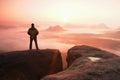 Moment of loneliness. Man on the rock empires and watch over the misty and foggy morning valley to Sun Royalty Free Stock Photo