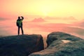 Moment of loneliness. Man on the rock empires and watch over the misty and foggy morning valley to Sun Royalty Free Stock Photo