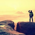 Moment of loneliness. Man on the rock empires and watch over the misty and foggy morning valley to Sun Royalty Free Stock Photo