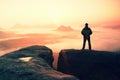 Moment of loneliness. Man on the rock empires and watch over the misty and foggy morning valley to Sun Royalty Free Stock Photo