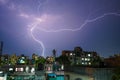 Moment of a massive lightning strike on the purple sky at night over the city