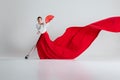 In moment of pure flamenco artistry, female dancer in vibrant red dress and fan, performing flamenco with elegance Royalty Free Stock Photo