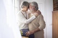 A moment of tenderness between two elderly people who hug each other with love in front of the window. Concept of love and