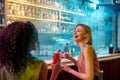 Moments of Happiness. Two women having fun, drinking cocktails while sitting at the bar counter. Friends spending time Royalty Free Stock Photo
