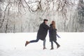 Moments of life. Gorgeous young couple playing and throwing snowballs in winter forest Royalty Free Stock Photo