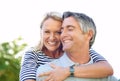 Moments to last a lifetime. Cropped portrait of an attractive mature woman on her husbands back in the park. Royalty Free Stock Photo