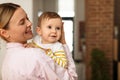 Mommy and baby daughter. Mother posing with little girl, holding her in hands and smiling, free space Royalty Free Stock Photo