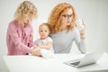 Mommy is concentrated on her work while her kids petting a little cat Royalty Free Stock Photo
